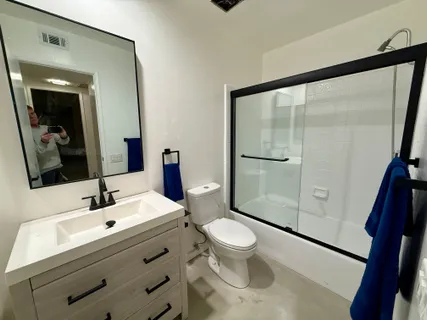 a bathroom with a sink a toilet and shower