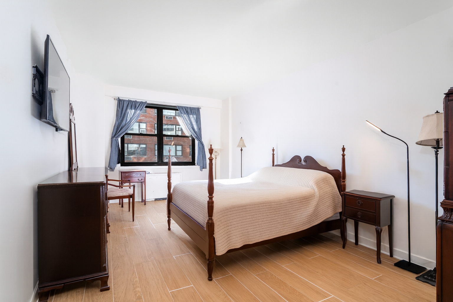 315 East 65th Street, Unit 8F Manhattan, NY 10065 - Photo 4 of 11 a bedroom with a bed window and a flat screen tv