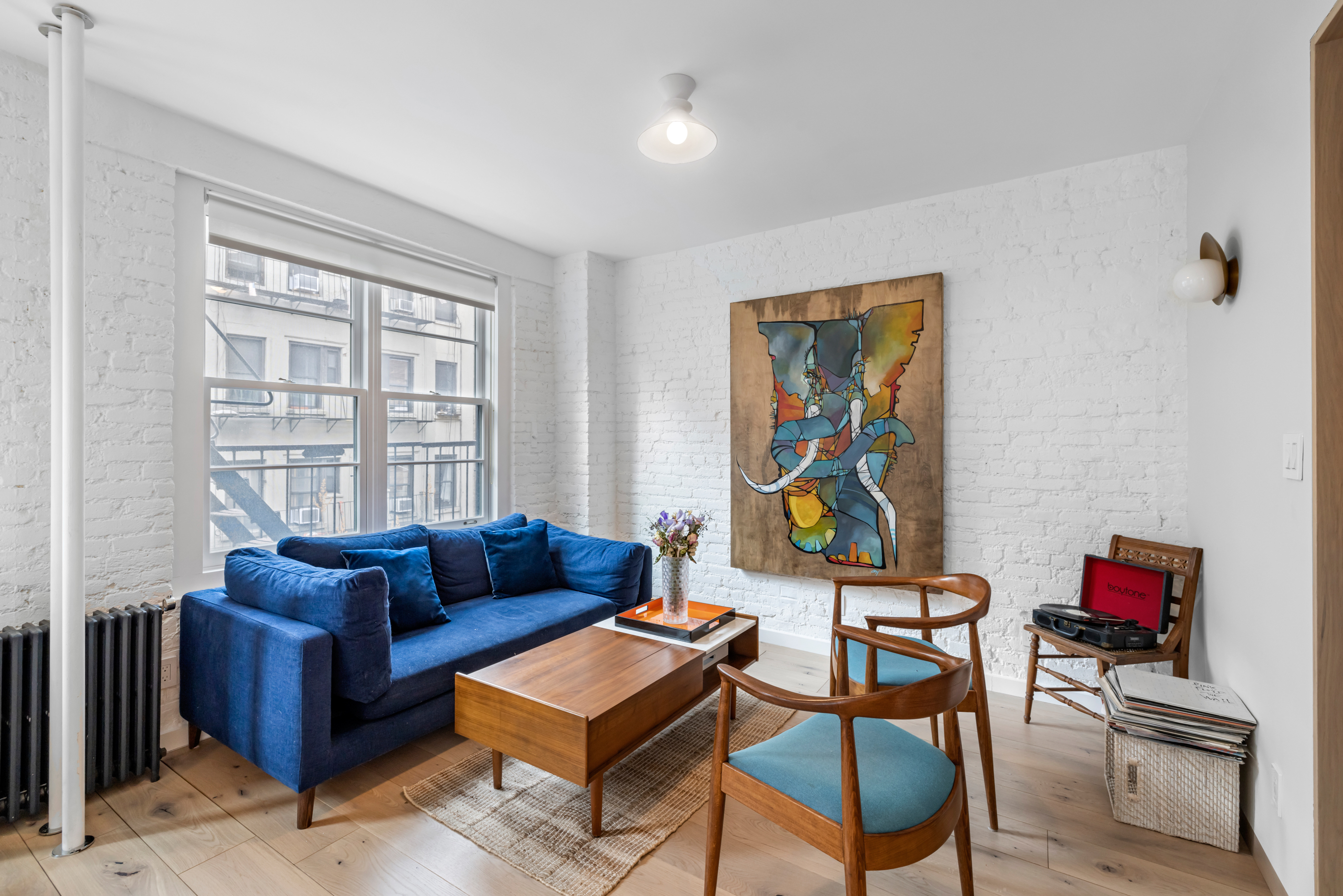 57 Thompson Street, Unit 4E Manhattan, NY 10012 - Photo 9 of 16 a living room with furniture and a window