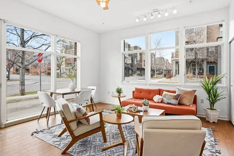 a living room with furniture and a floor to ceiling window