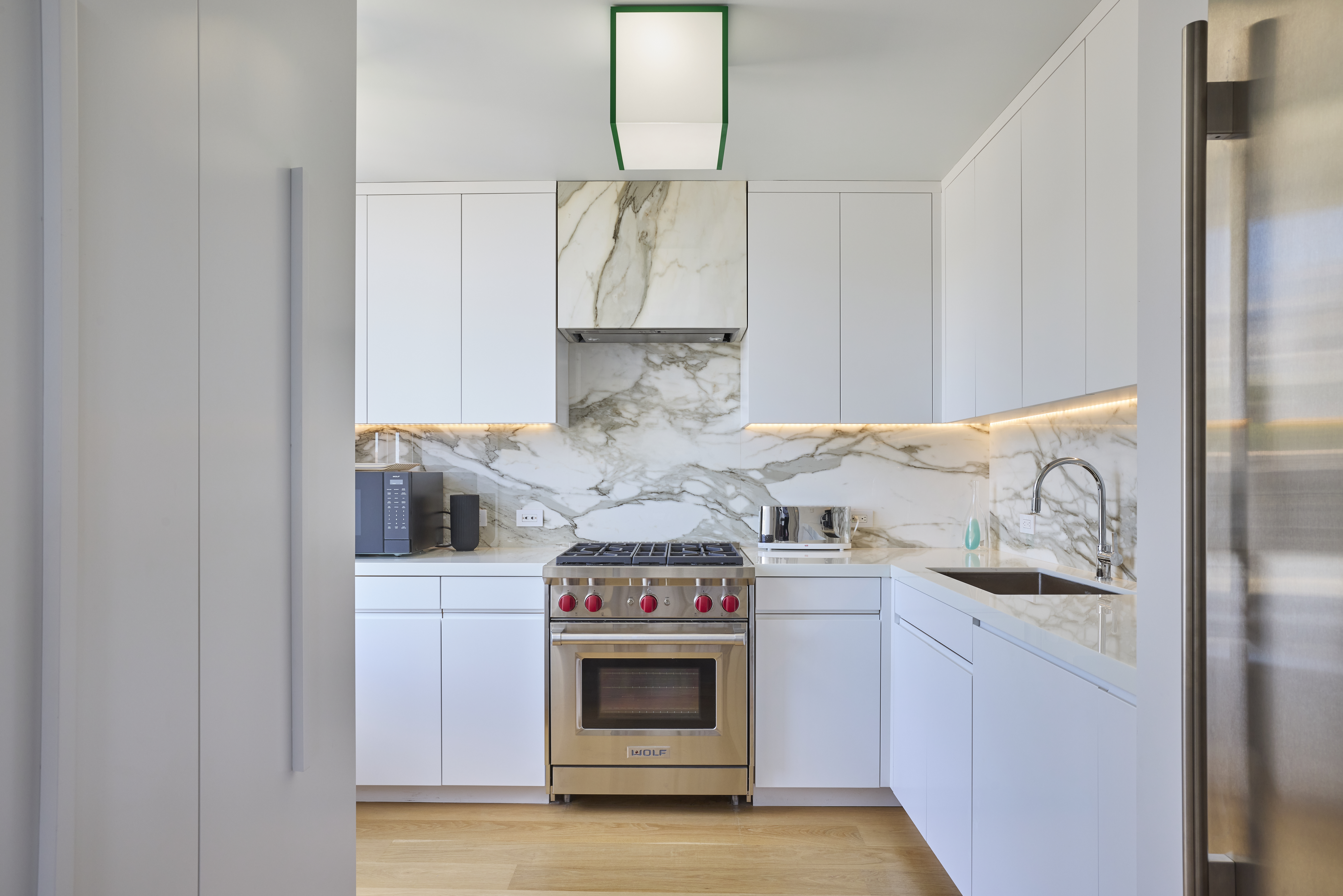 1001 5th Avenue, Unit 18A Manhattan, NY 10028 - Photo 6 of 13 a kitchen with stainless steel appliances granite countertop a stove and a refrigerator