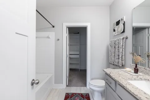 a bathroom with a granite countertop sink toilet and shower