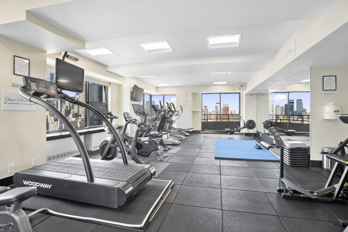 400 East 70th Street, Unit 3005 Manhattan, NY 10021 - Photo 16 of 18 a room with lots of chairs and mirrors