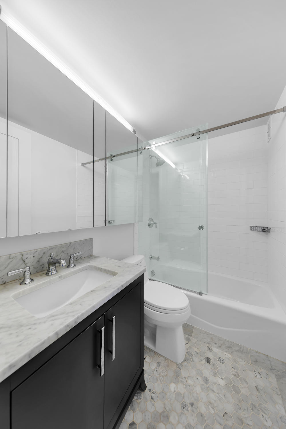 200 East 94th Street, Unit 315 Manhattan, NY 10128 - Photo 15 of 25 a bathroom with a sink a toilet and shower