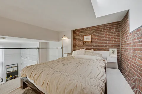 a bedroom with a bed and a lamp on dresser