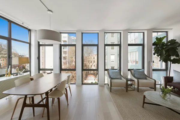 a living room with furniture and large windows with wooden floor