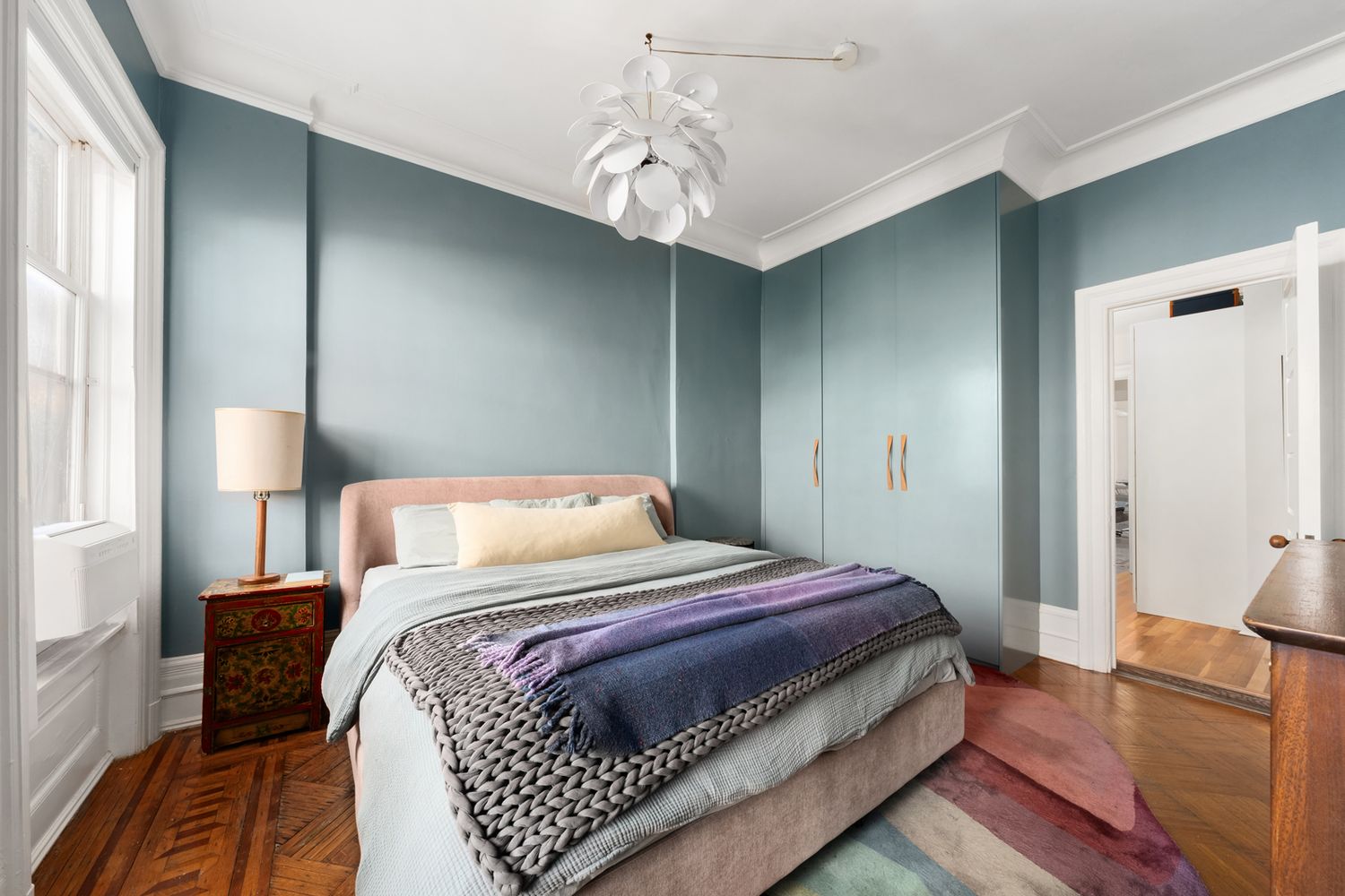 a bedroom with a bed and wooden floor