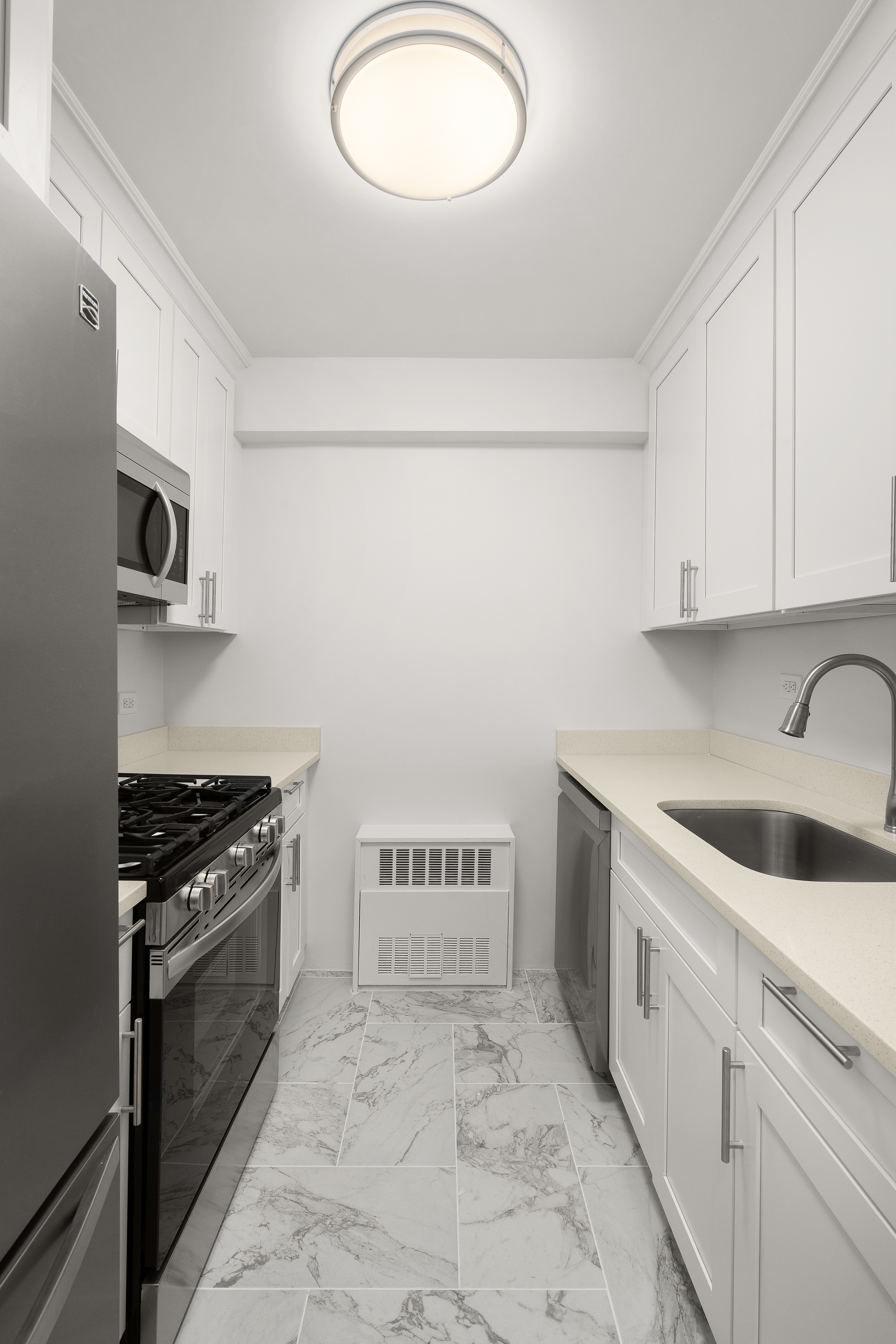 401 East 65th Street, Unit 11G Manhattan, NY 10065 - Photo 3 of 6 a kitchen with a stove and a sink