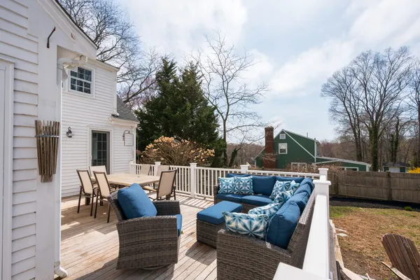 a view of a patio with couches chairs and wooden floor