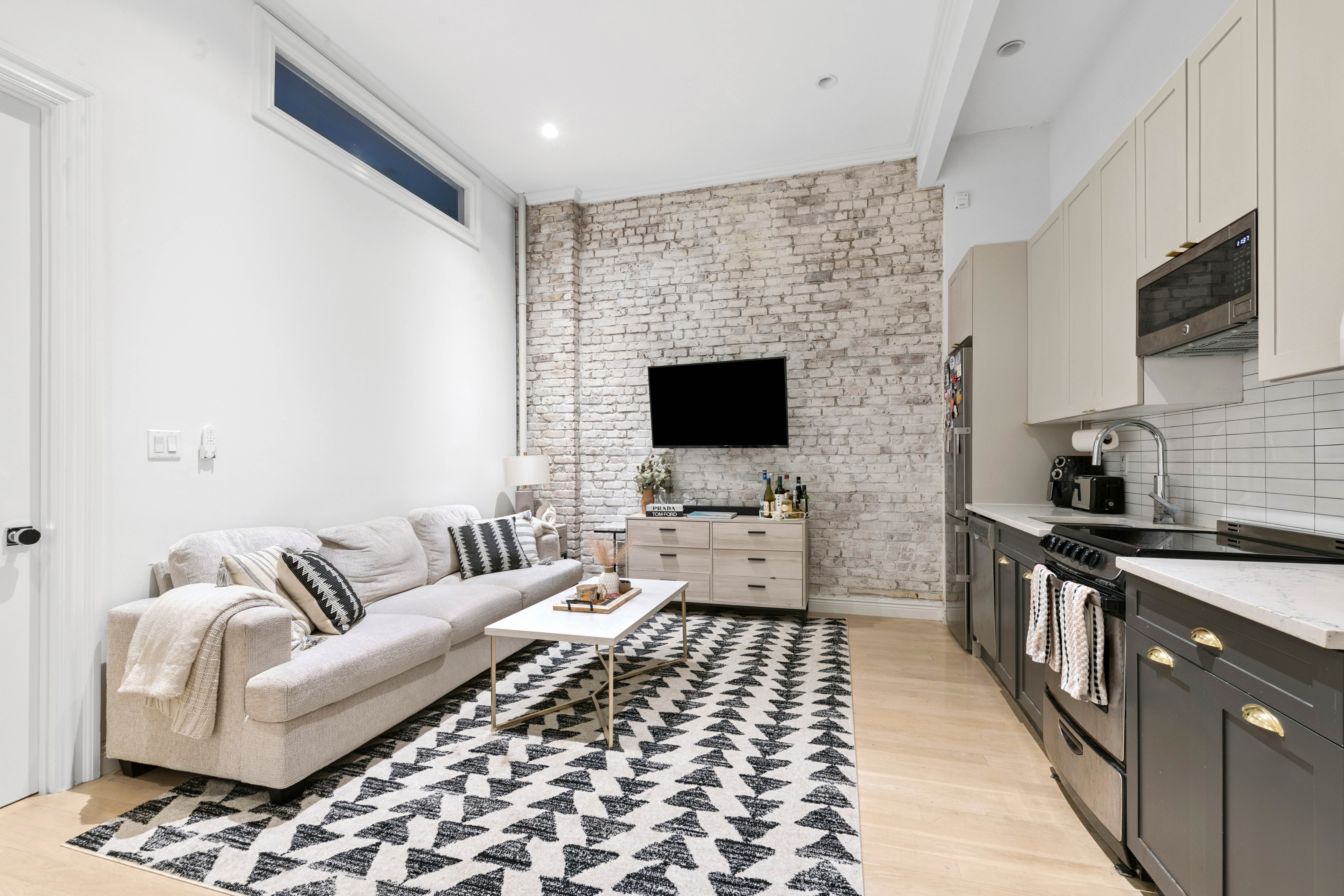 51 West 11th Street, Unit 1R Manhattan, NY 10011 - Photo 2 of 10 a living room with furniture and a flat screen tv