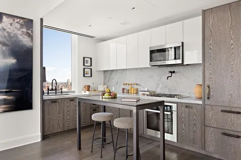 a kitchen with stainless steel appliances a sink a stove a table and chairs