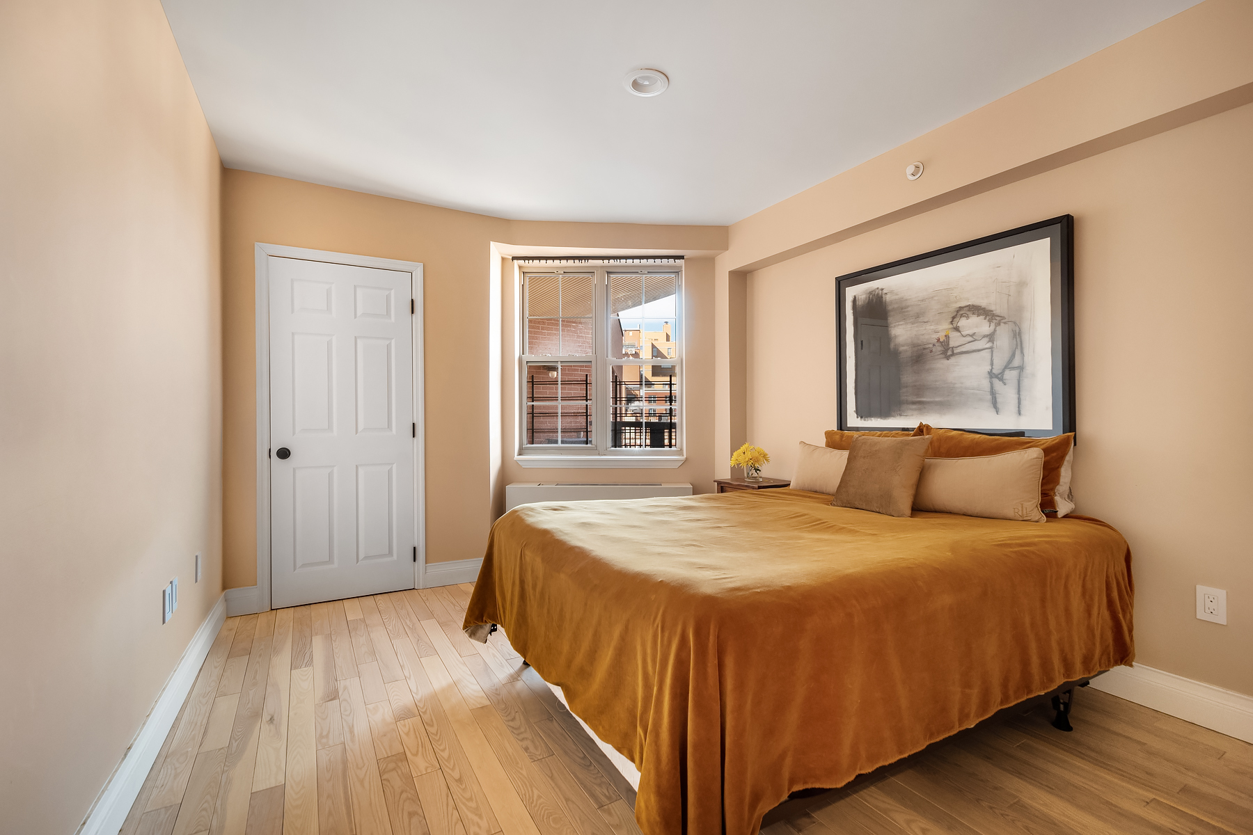 163 St Nicholas Avenue, Unit PH7A Manhattan, NY 10026 - Photo 4 of 11 a bedroom with a large bed and wooden floor