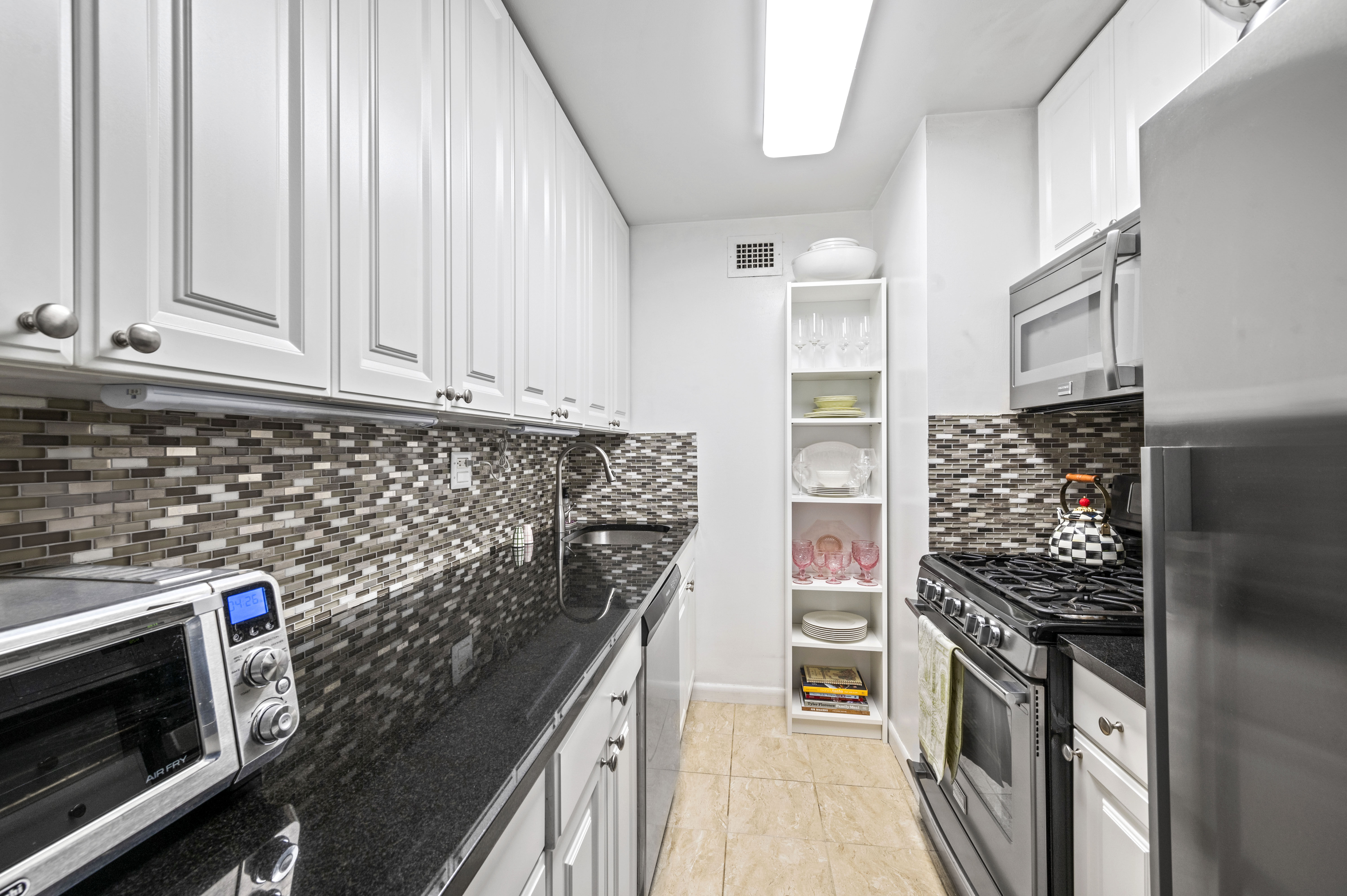 310 East 46th Street, Unit 19F Manhattan, NY 10017 - Photo 7 of 17 a kitchen with a stove and a microwave
