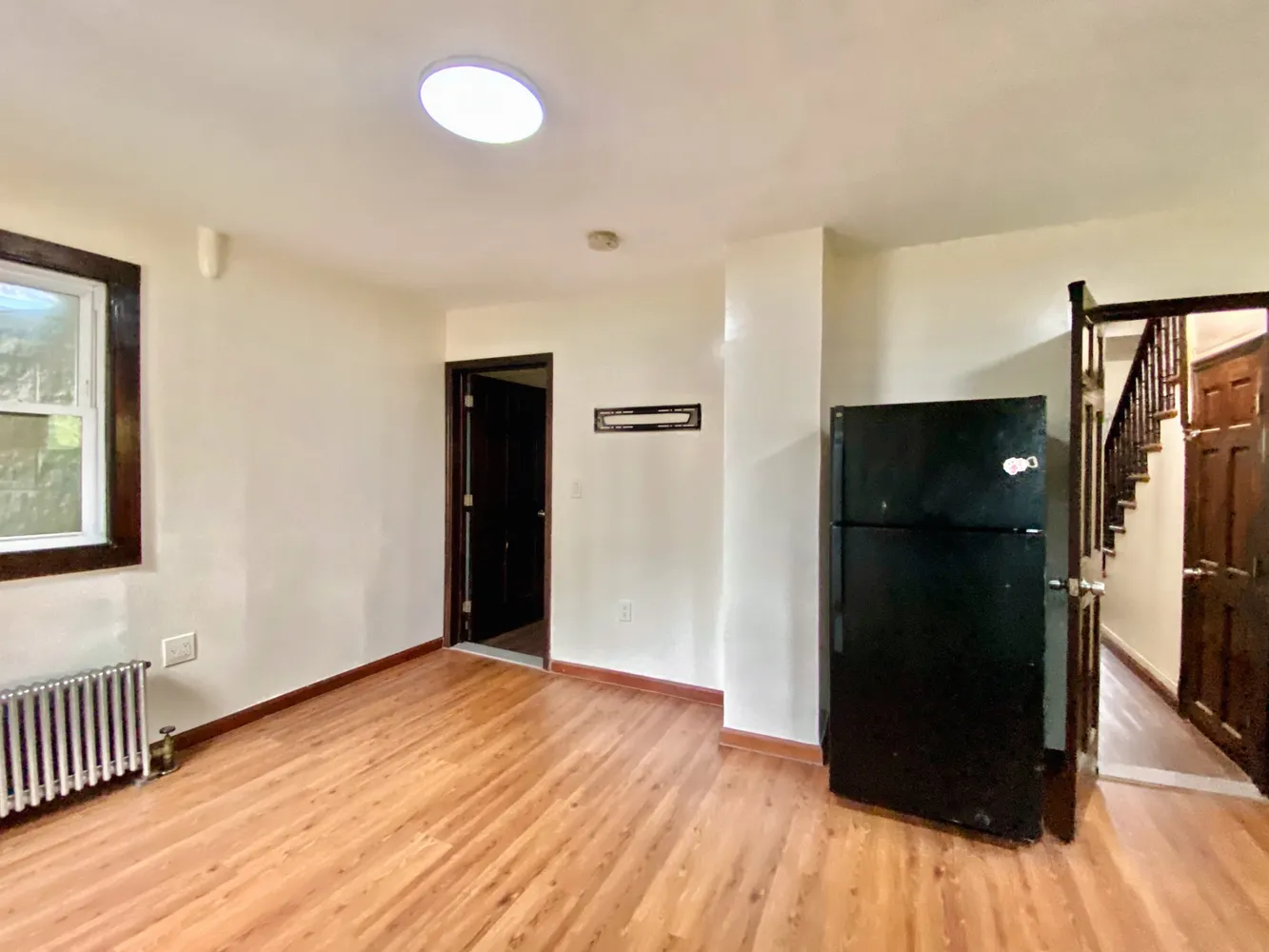 a view of a hallway with wooden floor and staircase