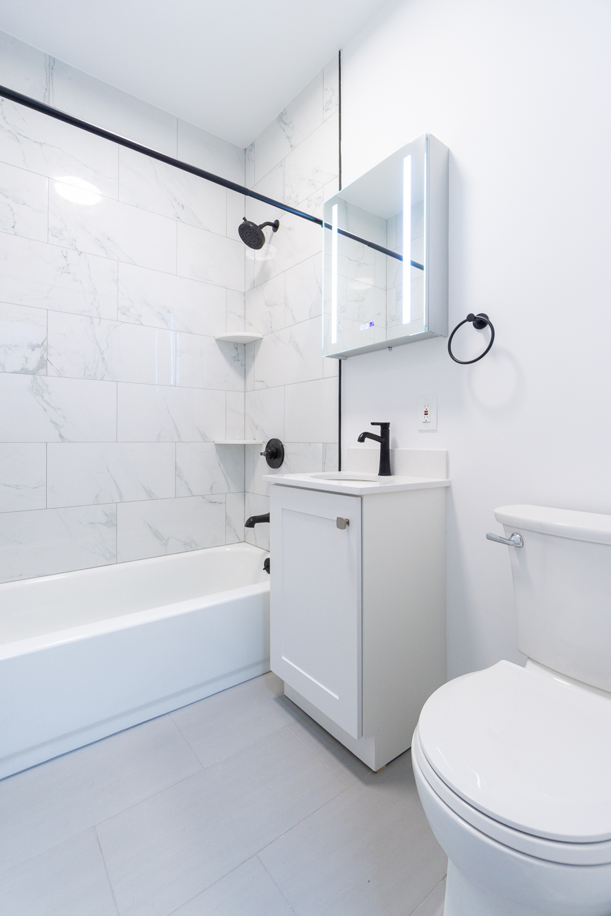 315 East 5th Street, Unit 5D Manhattan, NY 10003 - Photo 6 of 8 a bathroom with a sink a mirror a toilet and bathtub