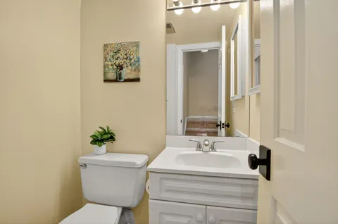 a bathroom with a sink toilet and mirror