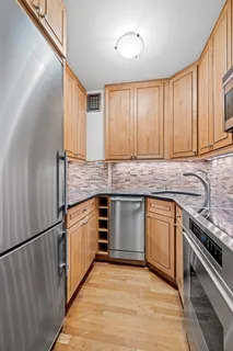 a kitchen with granite countertop a sink a stove and cabinets