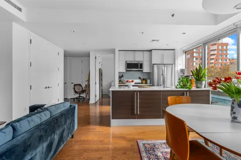 a large kitchen with kitchen island granite countertop a sink a counter top space and stainless steel appliances