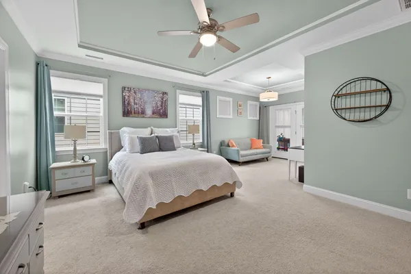 a spacious bedroom with a bed mirror and window