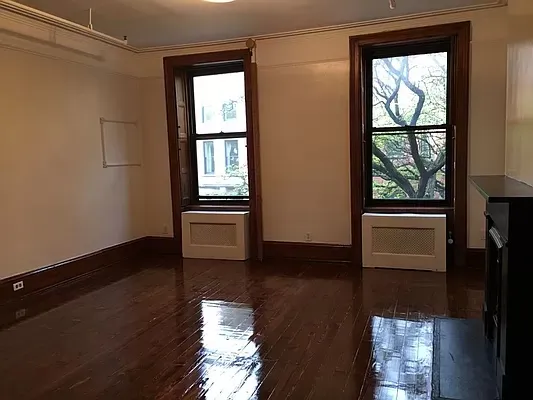 a view of a small space with wooden floor and a window
