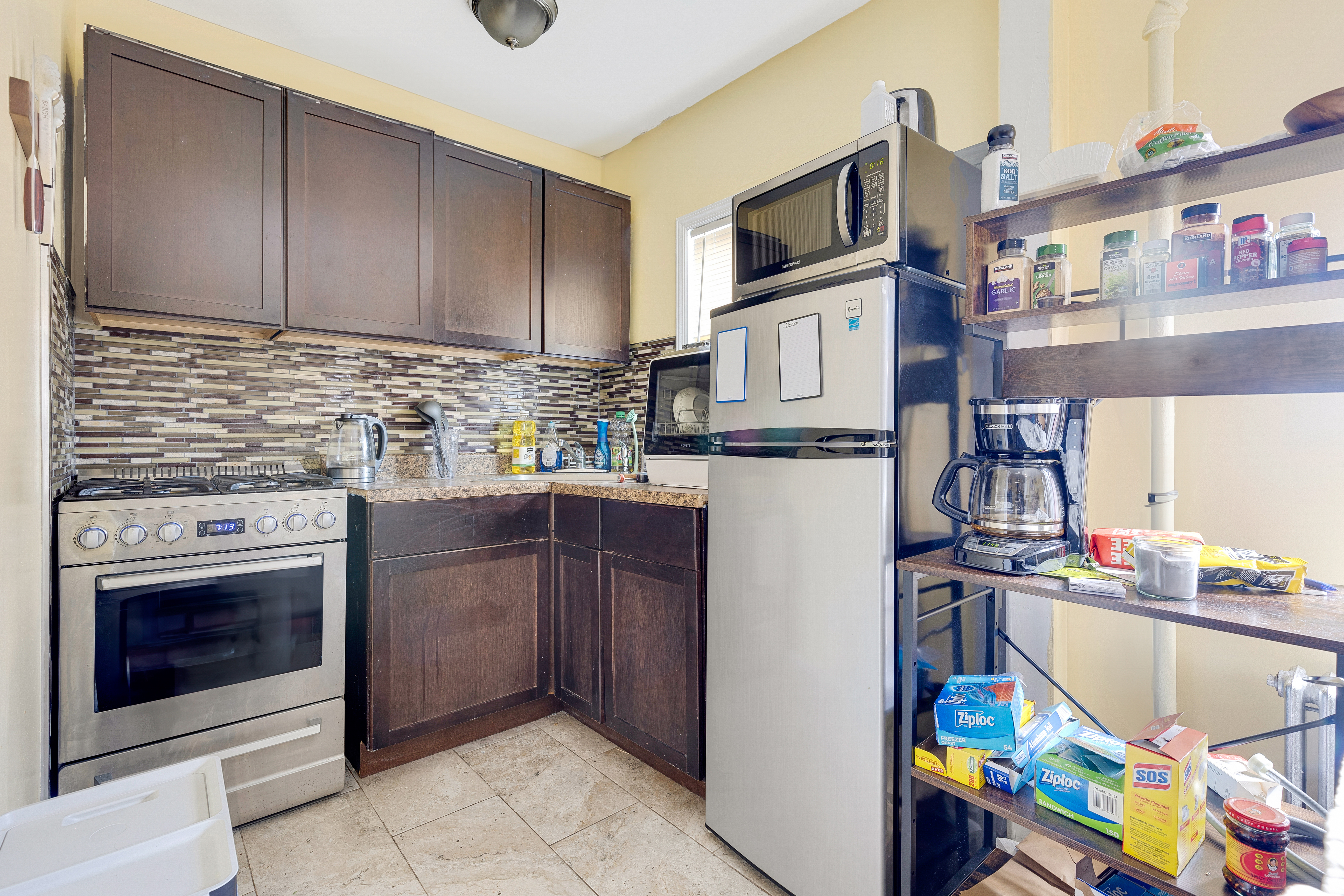 35-47 30th Street Queens, NY 11106 - Photo 7 of 14 a kitchen with stainless steel appliances granite countertop a stove and a microwave