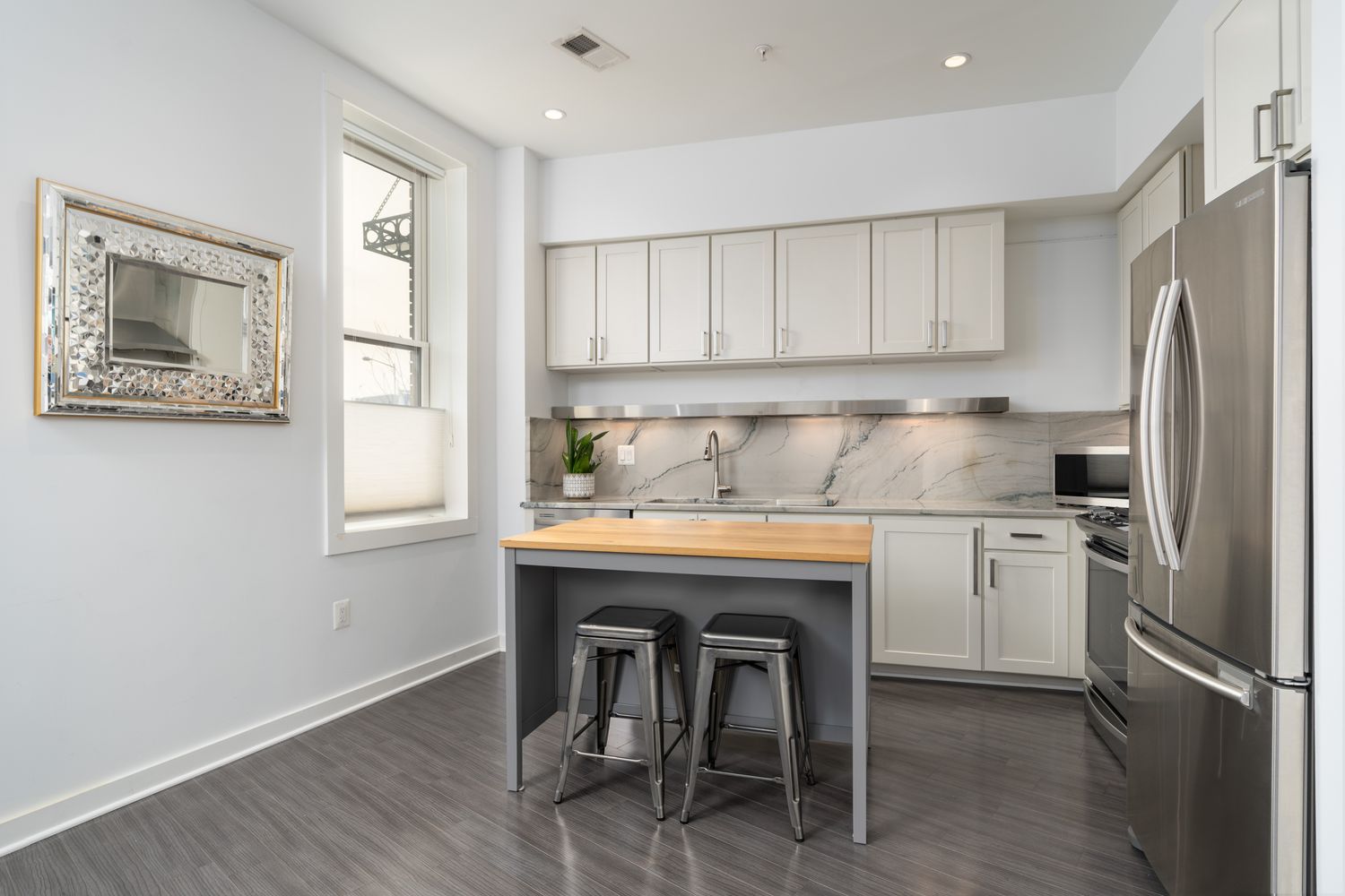 a kitchen with a refrigerator a sink and a stove top open