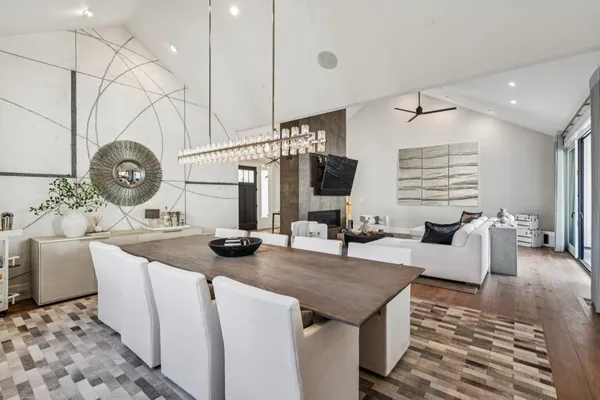 a kitchen with a dining table chairs sink and cabinets