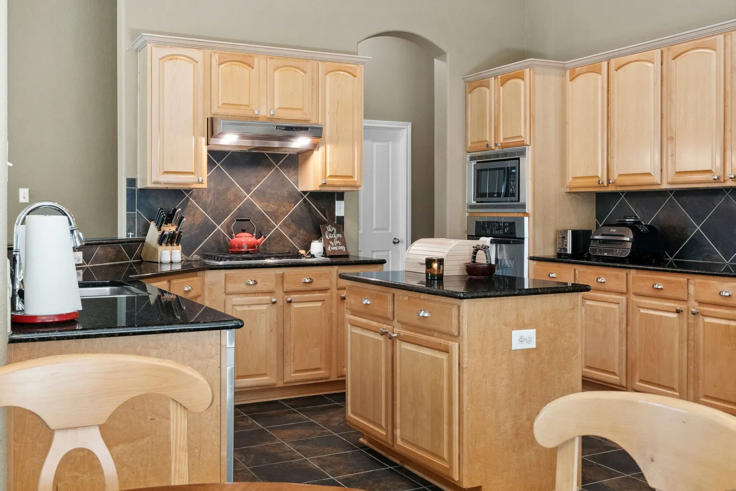 a kitchen with stainless steel appliances granite countertop a sink stove and cabinets