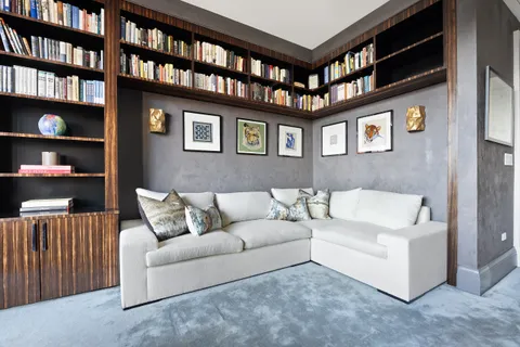 a living room with furniture and a book shelf