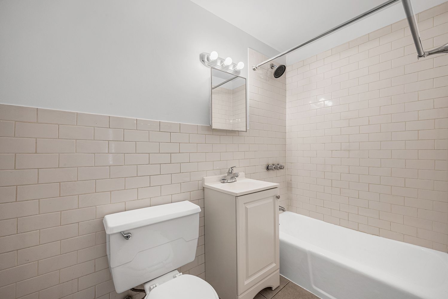 1105 1st Avenue, Unit 5 Manhattan, NY 10065 - Photo 4 of 5 a white toilet sitting next to a bath tub