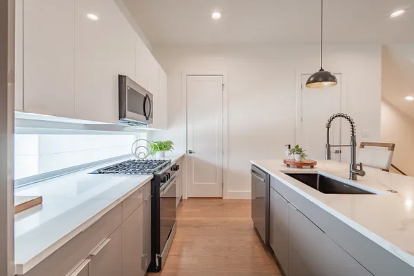a kitchen with a dining table chairs and white cabinets