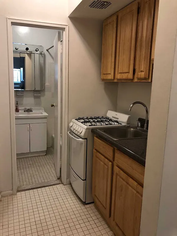 237 East 79th Street, Unit 1B Manhattan, NY 10075 - Photo 6 of 7 a kitchen with a sink and cabinets