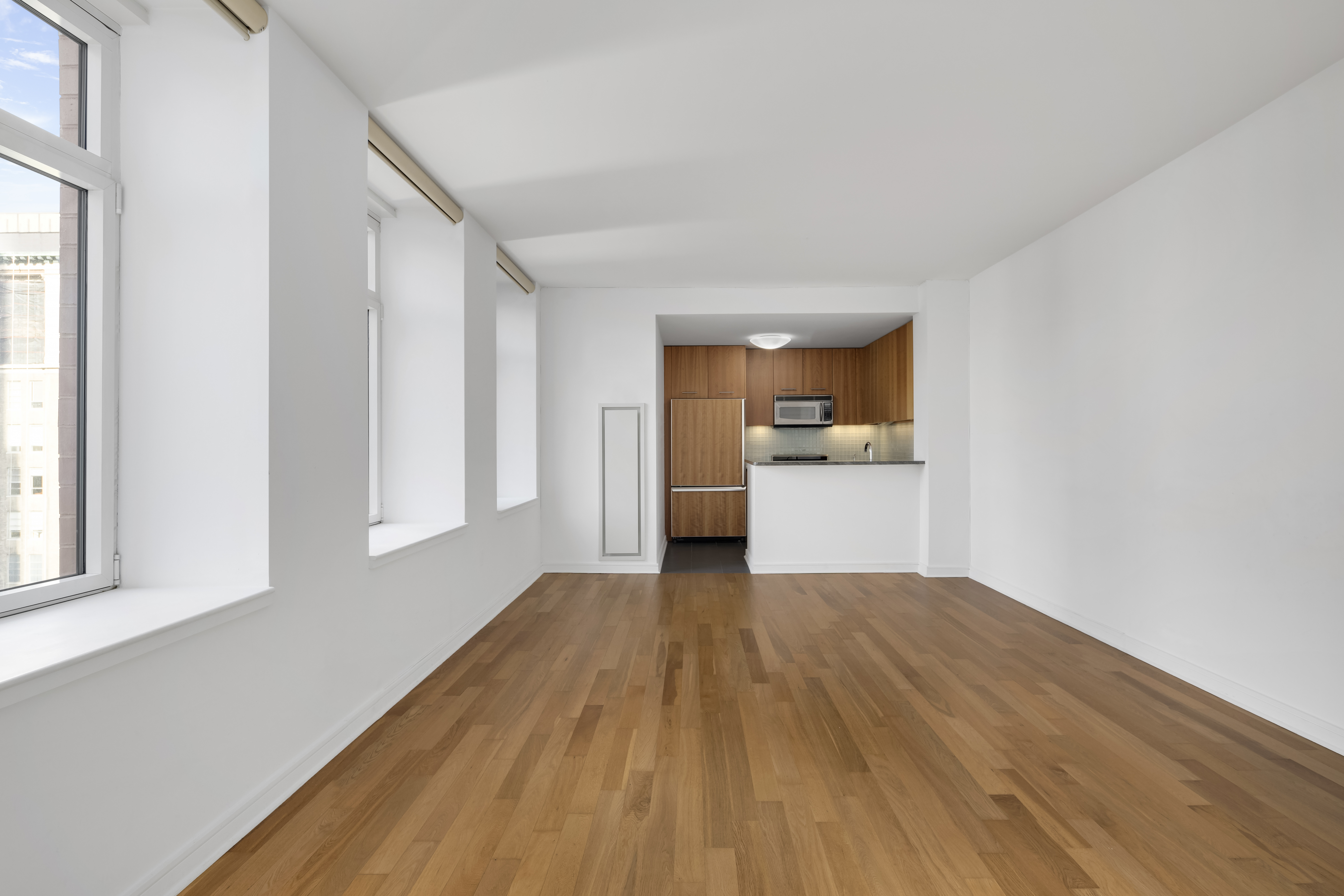 11 East 29th Street, Unit 15B Manhattan, NY 10016 - Photo 3 of 8 a view of a kitchen with wooden floor and a refrigerator