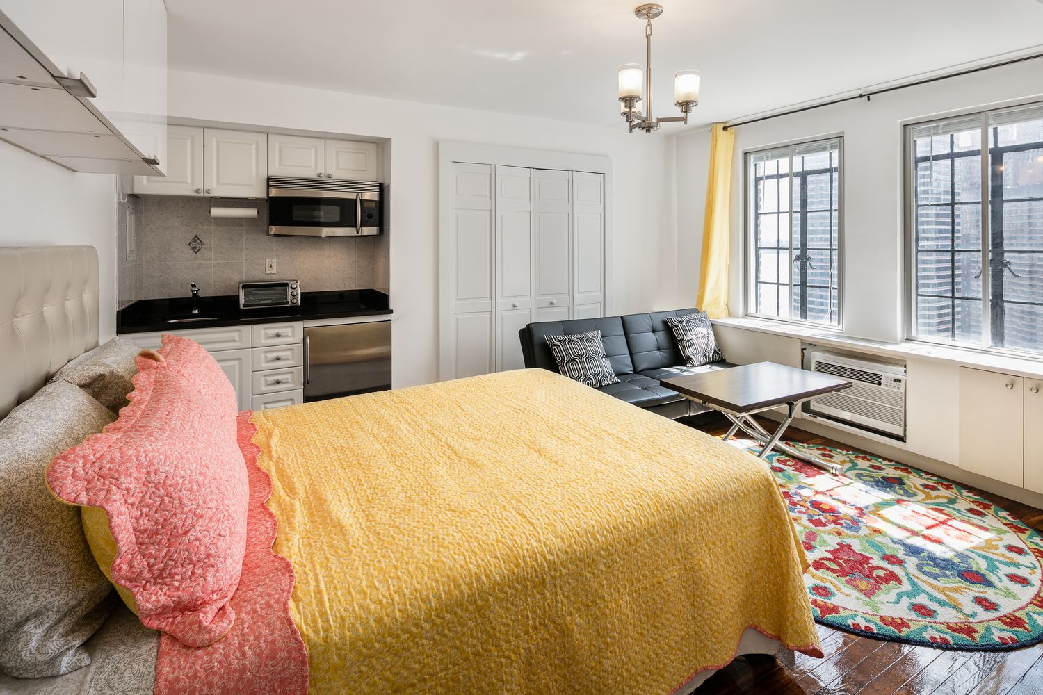 a large bed sitting in a bedroom next to a window with workspace