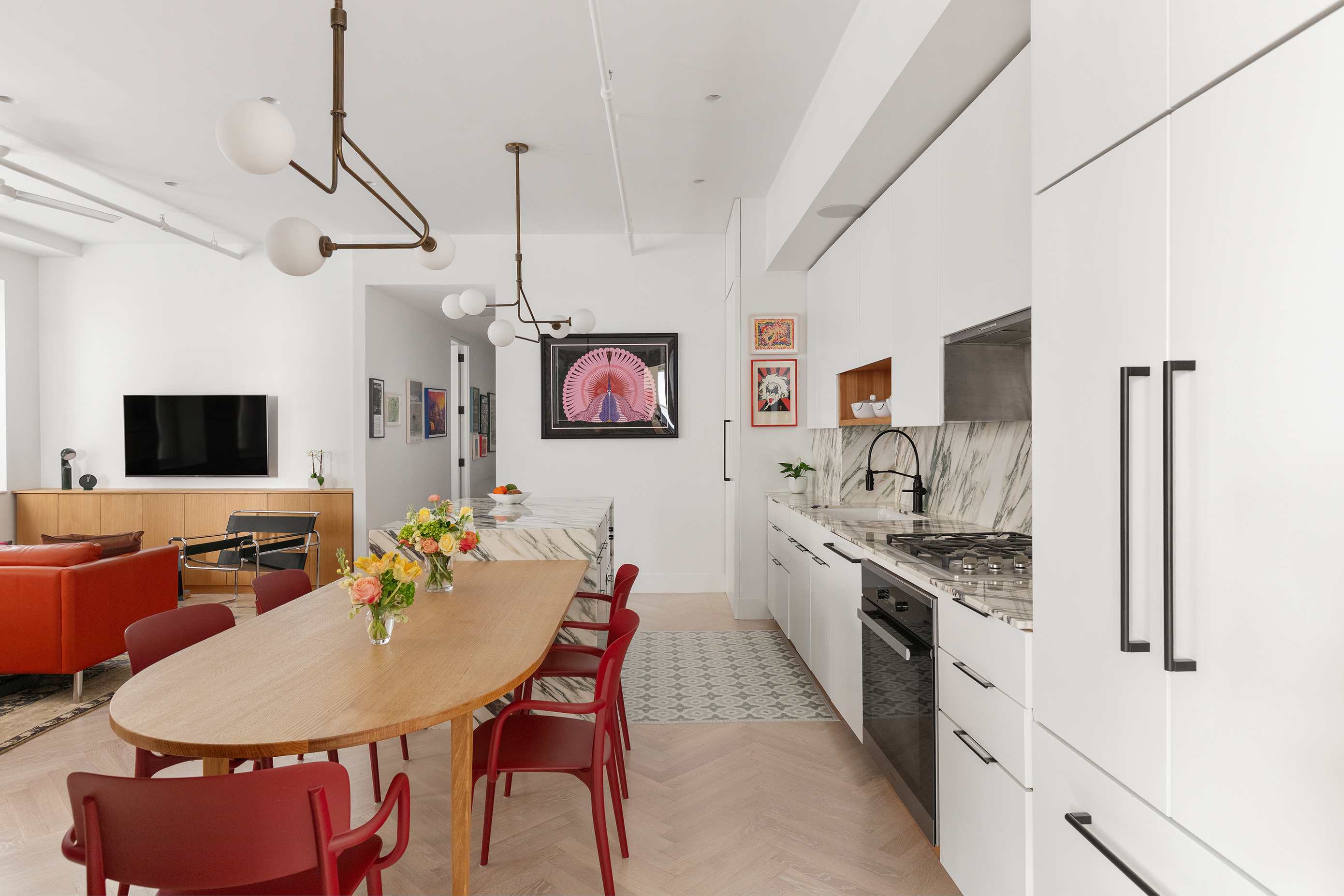143 West 27th Street, Unit 2R Manhattan, NY 10001 - Photo 3 of 13 a kitchen with stainless steel appliances kitchen island granite countertop a stove a sink dishwasher a dining table and chairs with wooden floor