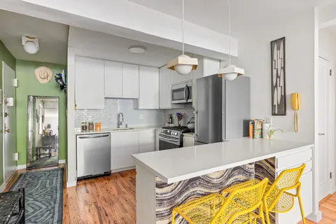 a kitchen with stainless steel appliances granite countertop a refrigerator a stove and a sink