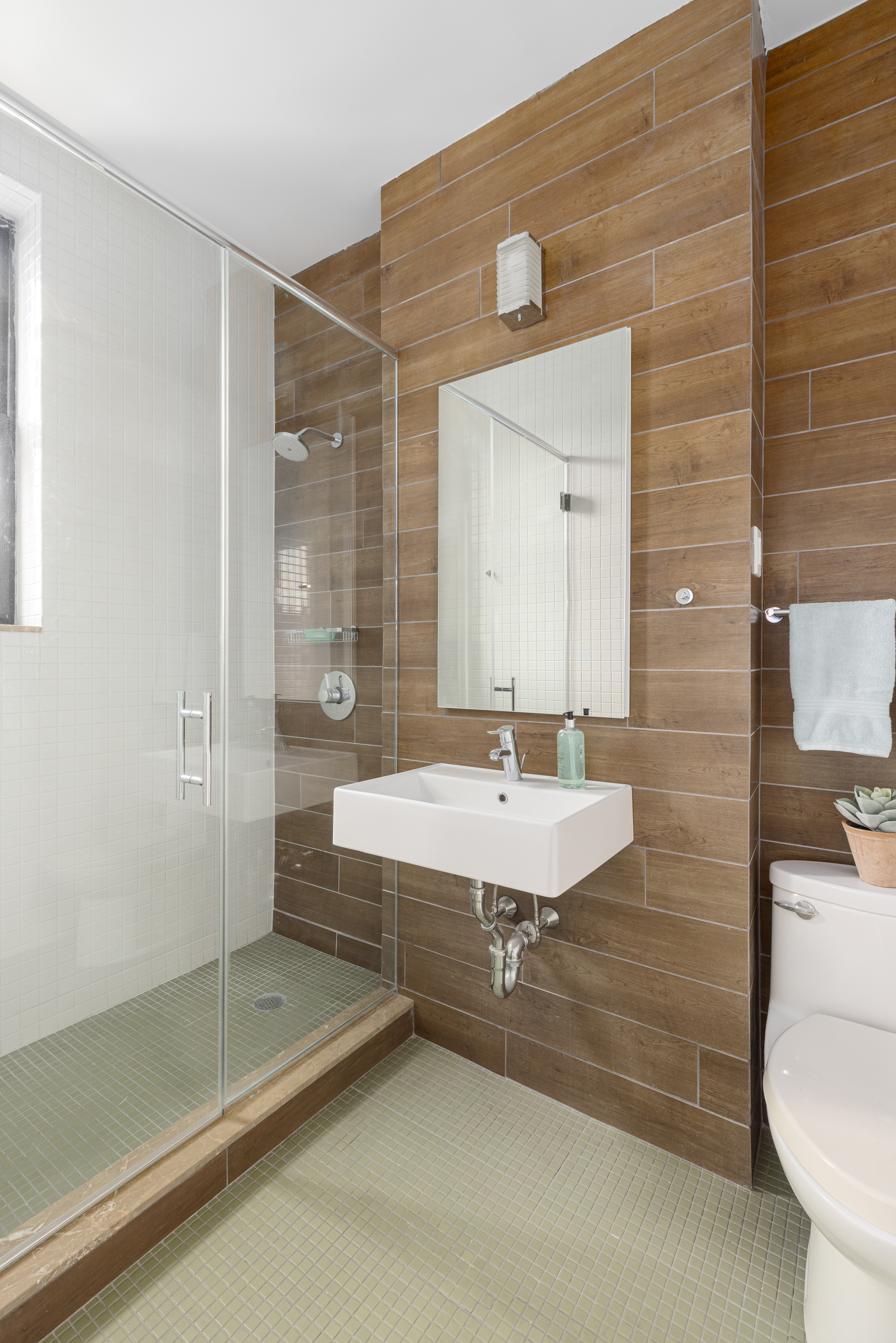 140 West 69th Street, Unit 56A Manhattan, NY 10023 - Photo 7 of 9 a bathroom with a sink a toilet a mirror and shower