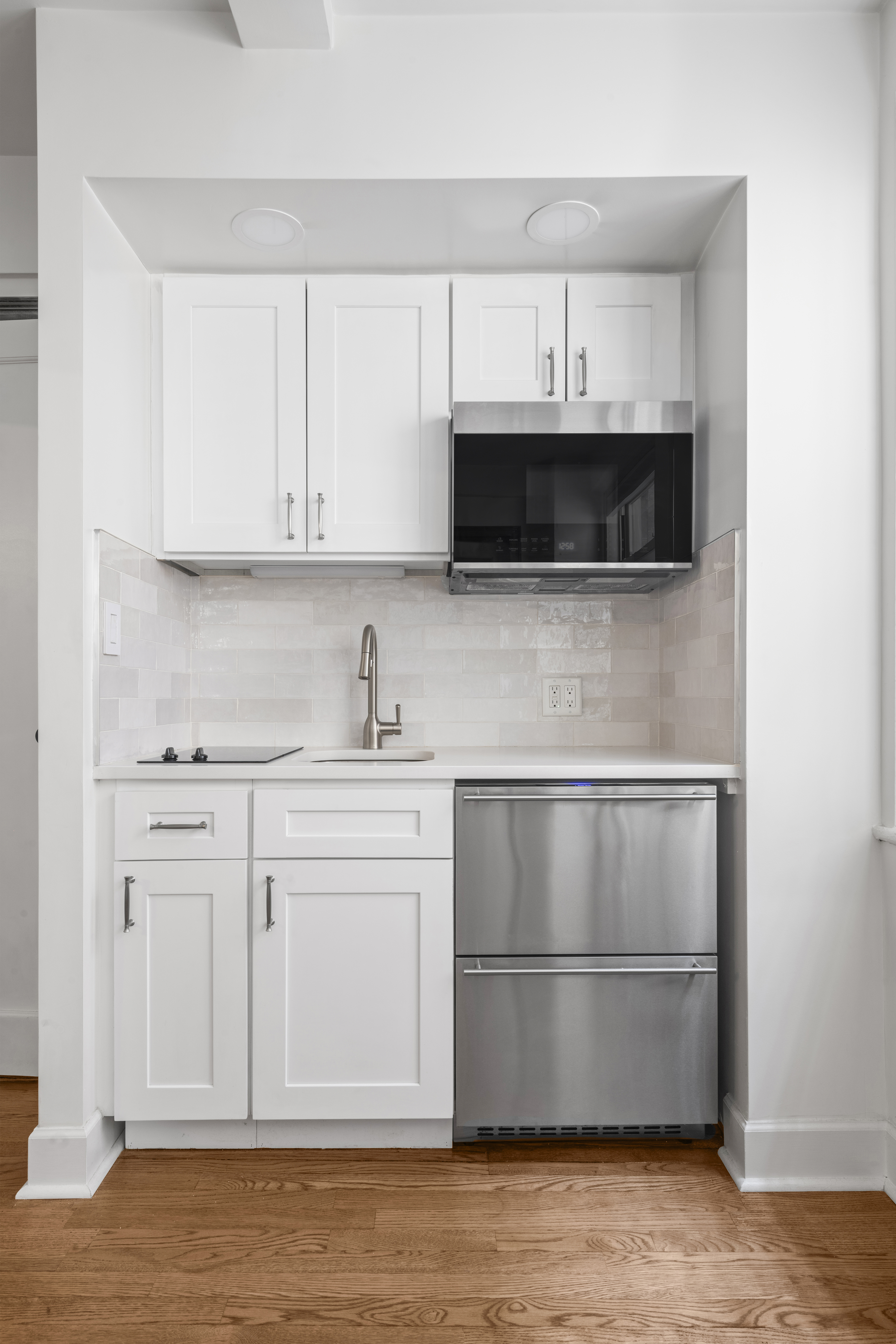 321 East 43rd Street, Unit 510 Manhattan, NY 10017 - Photo 2 of 8 a kitchen with stainless steel appliances a stove microwave and cabinets