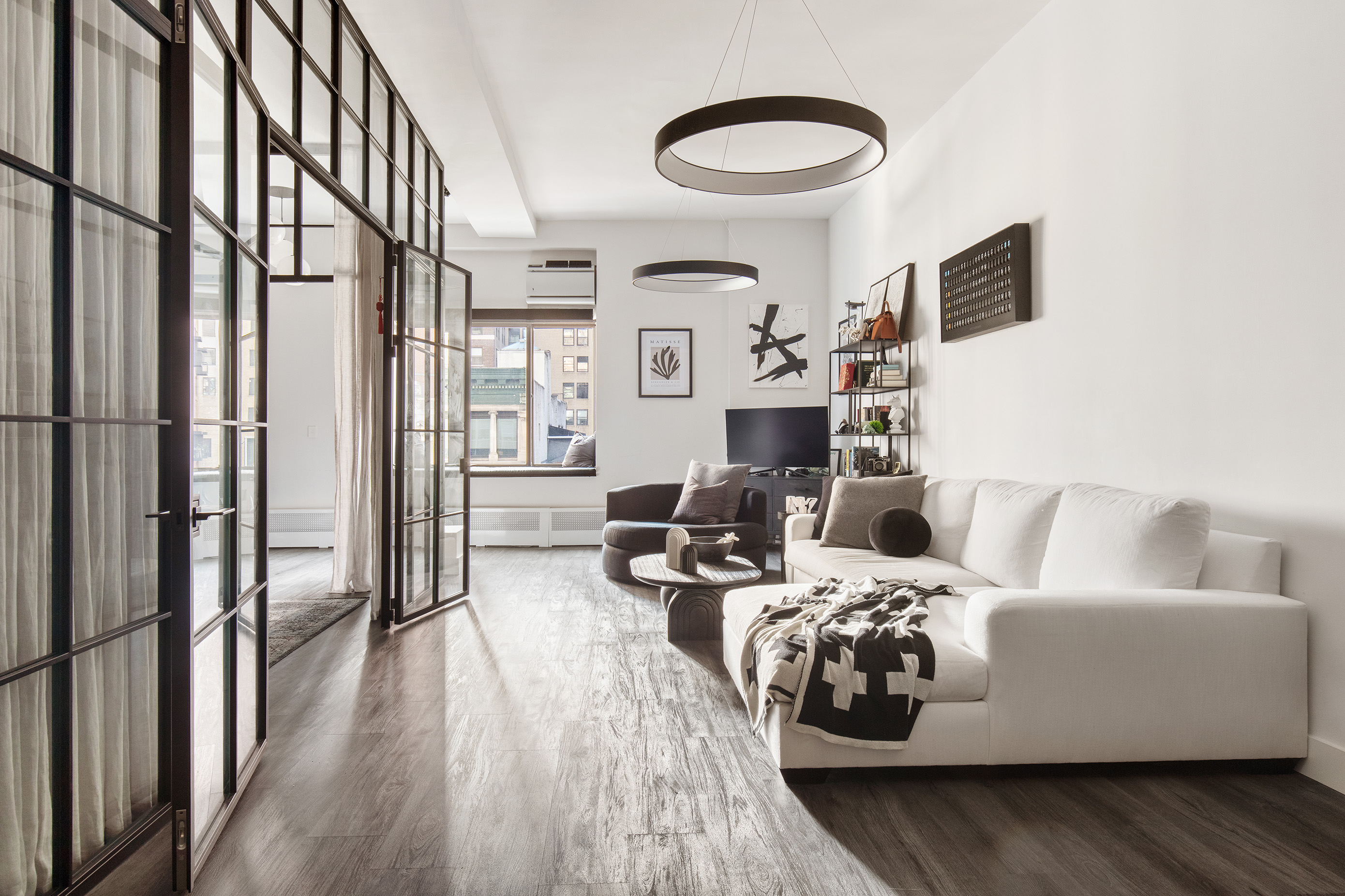 a living room with furniture and a wooden floor