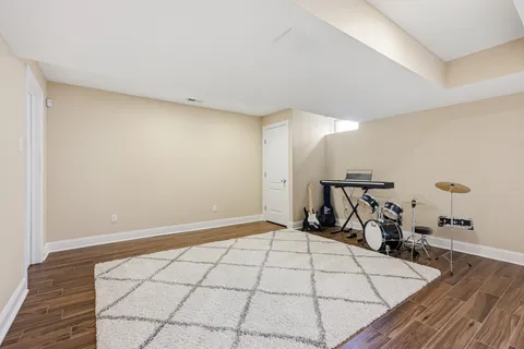 a view of a house next to a big yard and large trees