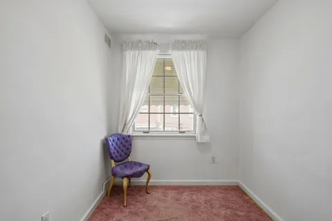 a living room with a chair and a window