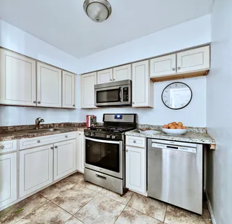 a kitchen with stainless steel appliances granite countertop a stove a microwave and cabinets