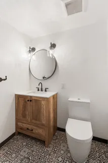 a bathroom with a toilet a sink and mirror