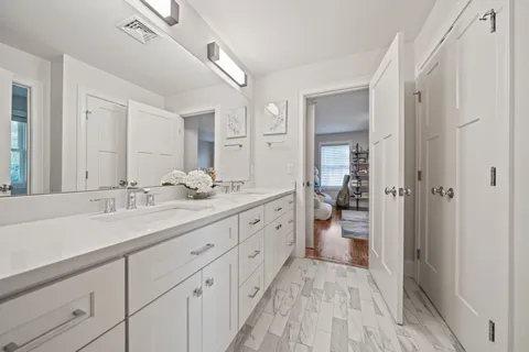 a spacious bathroom with a sink a toilet and a large mirror