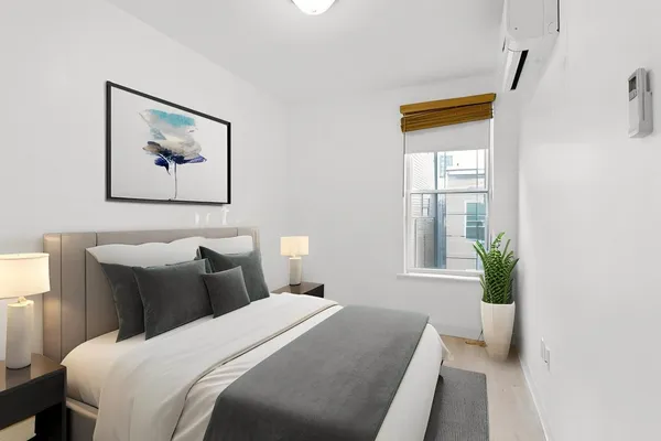 a bedroom with a bed and a painting on the wall
