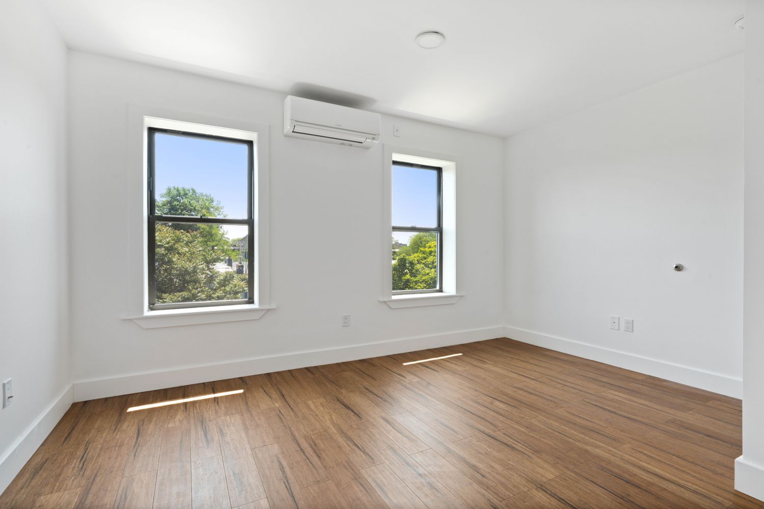 692 Putnam Avenue, Unit 2 Brooklyn, NY 11221 - Photo 8 of 15 a view of an empty room with wooden floor and a window