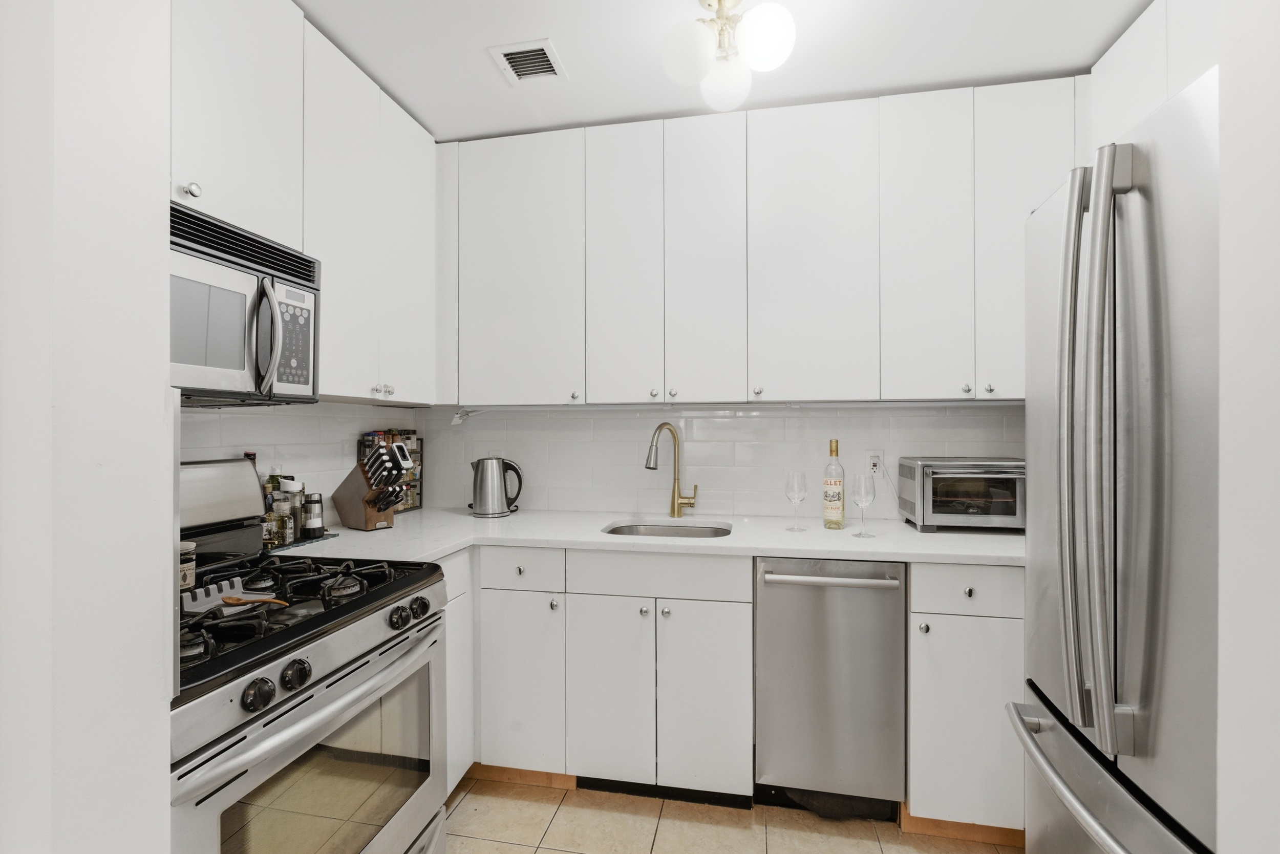 392 11th Street, Unit 3A Brooklyn, NY 11215 - Photo 3 of 11 a kitchen with stainless steel appliances white cabinets and a stove top oven
