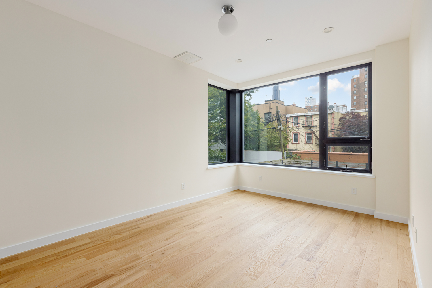 74 Adelphi Street, Unit 2B Brooklyn, NY 11205 - Photo 4 of 9 wooden floor in an empty room with a window