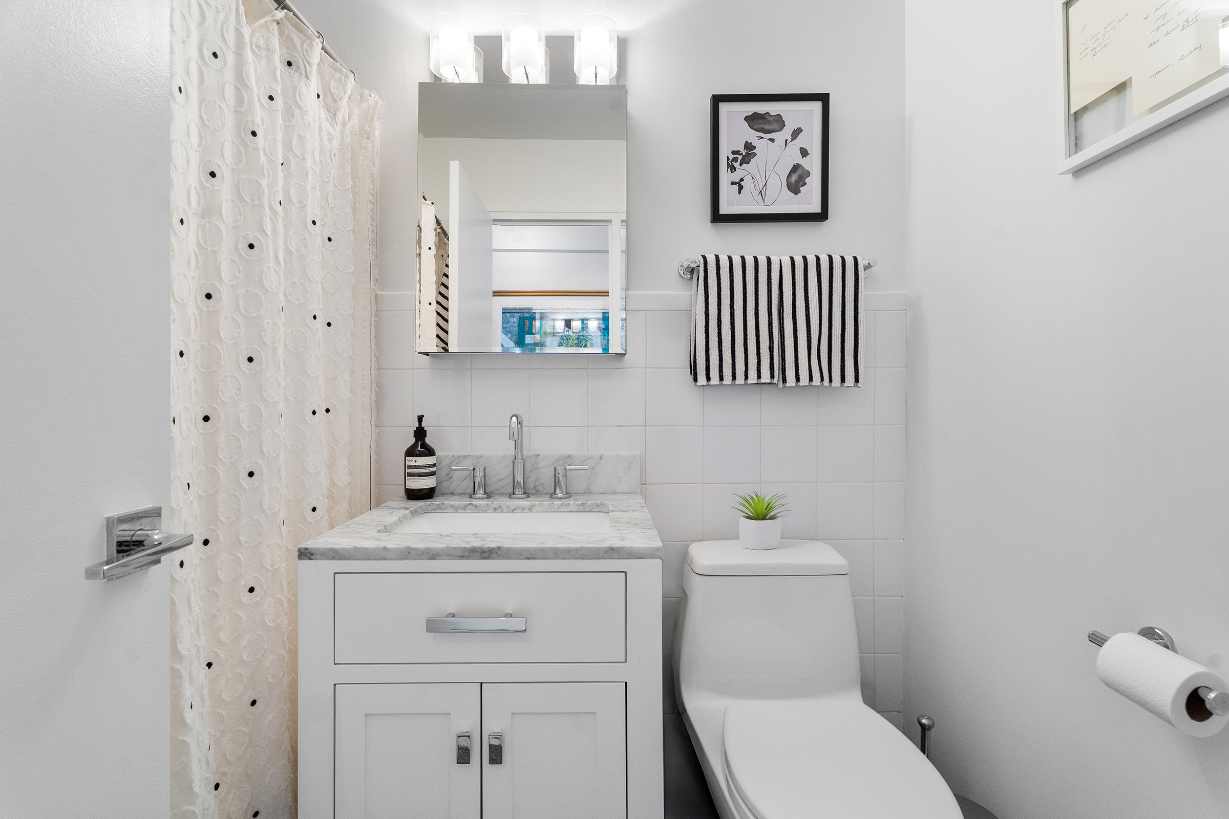333 East 14th Street, Unit 10D Manhattan, NY 10003 - Photo 6 of 8 a bathroom with a toilet a sink and a mirror