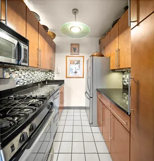 a kitchen with stainless steel appliances granite countertop a stove a refrigerator and a microwave